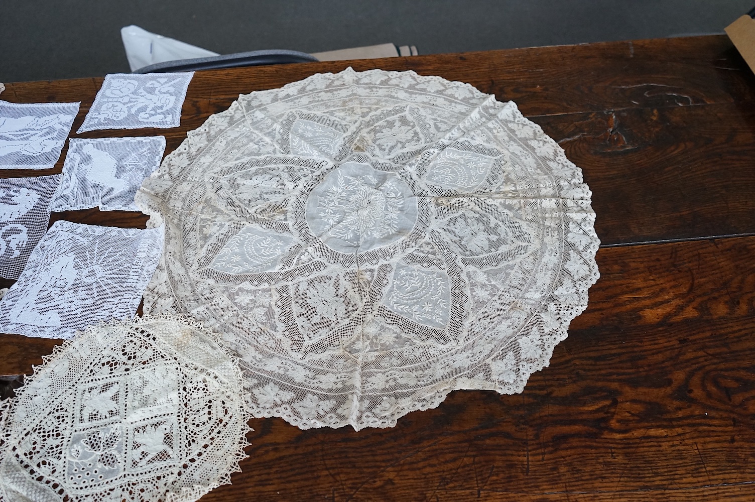 A good collection filet lace including a wide figurative elephant panel, square inserts, mats, trimming etc, with two Normandy lace mats, a cutwork mat and bobbin lace inserts.(40). Fillet panel 112cm long x 27cm wide. C